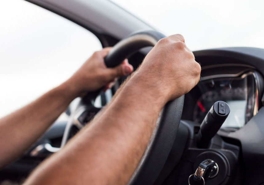 Hands on the steering wheel of a car.