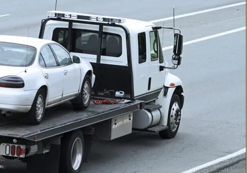 a truck transporting a car on a highway